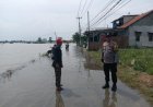 Bhabinkamtibmas Polsek Telukjambe Timur, Monitor Kondisi Banjir di Desa Sukamakmur Pasca Hujan Deras
